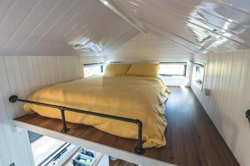 a bed in the middle of a tiny house at Tiny Hideaway at Cloverhills in Newham