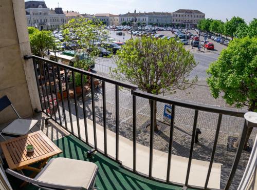 a balcony with a table and chairs and a parking lot at Sugovica Superior in Baja