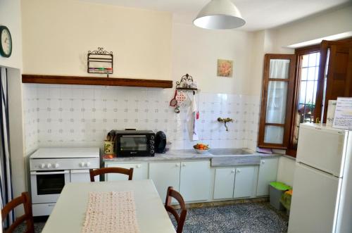 a kitchen with a table and a microwave and a refrigerator at Rifugio al mare della Versilia in Strettoia