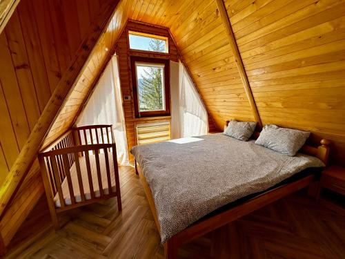 a bedroom with a bed in a wooden cabin at Krajina IV & jacuzzi in Vlasic