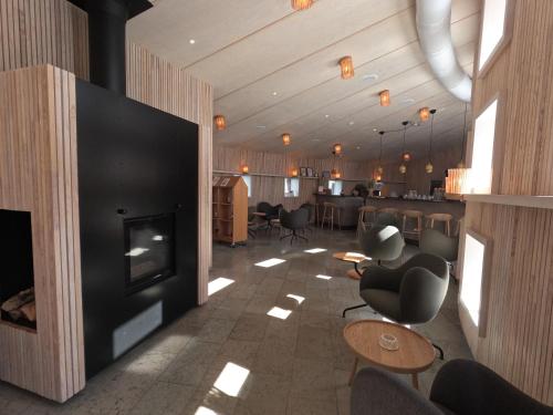 a lobby with a fireplace and chairs and a bar at Arctic Bath in Harads