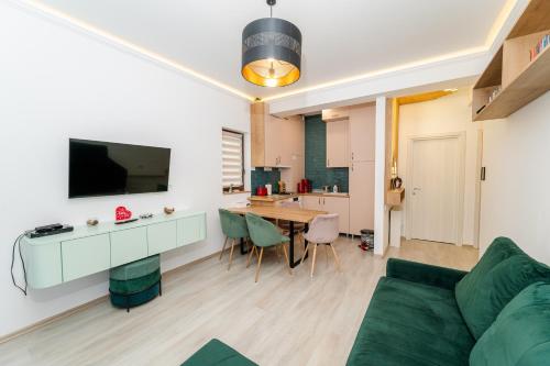 a living room with a green couch and a table at Cross Caraiman View 1 in Buşteni