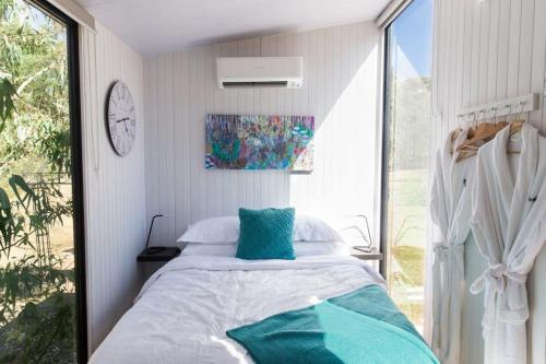 um quarto com uma cama e uma grande janela em Womburra Vineyard Tiny Stay 