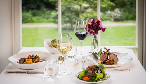 a table with plates of food and glasses of wine at Ballymaloe House Hotel in Ballycotton