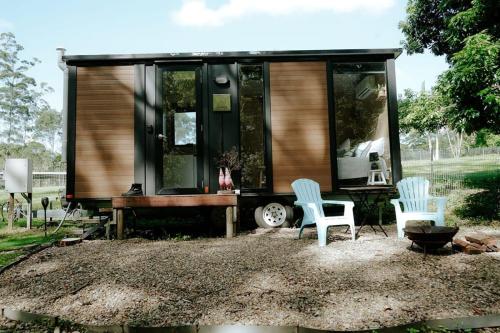 a tiny house with two chairs and a table at Cockatoo Cabin in Palmwoods