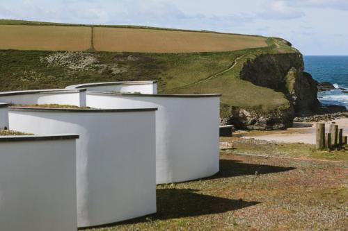 a white building on a beach with the ocean at Scarlet Hotel - Adults Only in Mawgan Porth