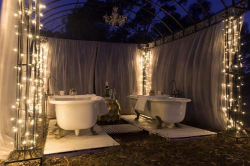 a bathroom with two sinks and two tubs with lights at Womburra Vineyard Tiny Stay 