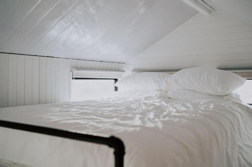 a white bed with white sheets and pillows at Little Baxter in Collector