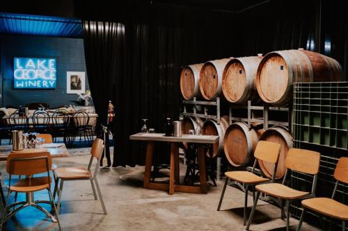 a room with a table and chairs and wine barrels at Little Baxter in Collector