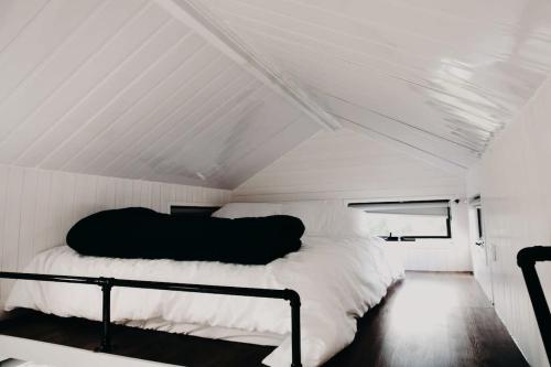 Macclesfield的住宿－Gums n Roses，一间白色客房内的床铺卧室