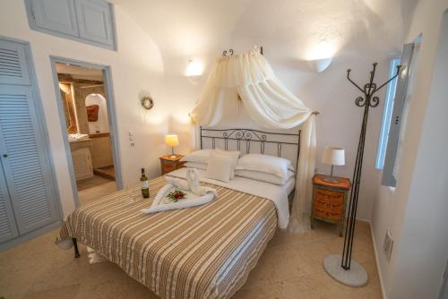 a bedroom with a bed with a canopy at Lithies Traditional Homes in Firostefani
