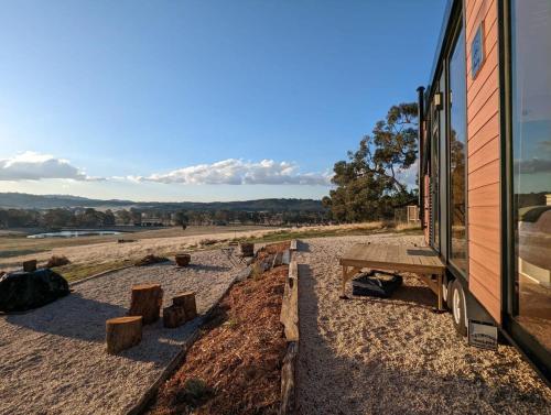 a building with a picnic table next to a building at Farm Stay at Sheltered Paddock 