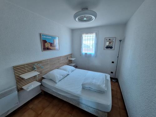 une petite chambre avec un lit et une fenêtre dans l'établissement ROCADE DE COLLIOURE appt T4 avec grande terrasse et garage, à Collioure