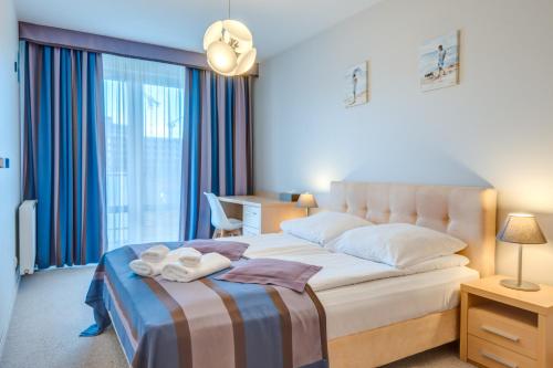 a hotel room with a bed with a towel on it at Aquarius Apartament 115 - 4 piętro widok w stronę morza in Kołobrzeg