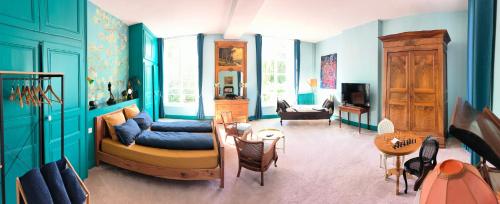 salon z niebieskimi ścianami i kanapą w obiekcie Le Grand Barrois w mieście Crecy la Chapelle