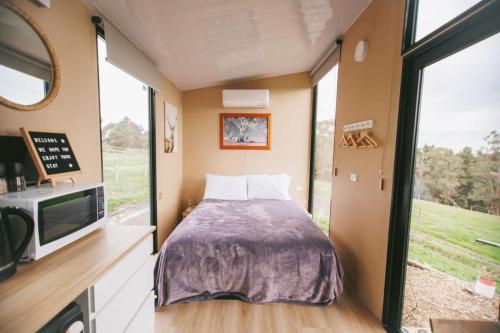a small bedroom with a bed and a tv at Rose Hill in Neerim South