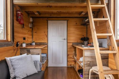 a tiny house with a staircase in a room at Stargazer in Axedale