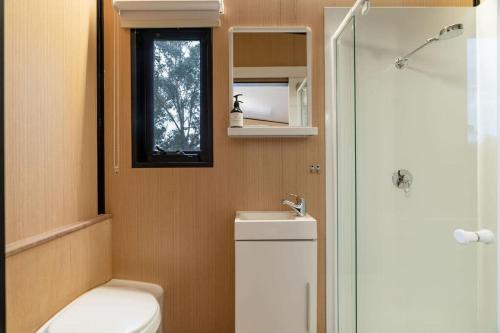 a bathroom with a toilet and a sink and a window at Prunus Hideaway 
