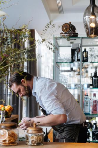 a man standing in a kitchen preparing food at Cosmopolite Hotel Nieuwpoort-Bad in Nieuwpoort