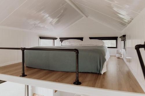 uma cama no meio de um quarto branco em Hill Creek Tiny House em Perwillowen