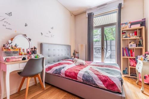 Schlafzimmer mit einem Bett, einem Schreibtisch und einem Fenster in der Unterkunft Appartement Luxueux avec Grande Terrasse in Charenton-le-Pont