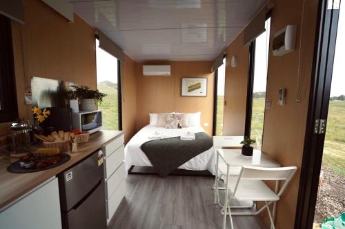 1 dormitorio con 1 cama, mesa y sillas en Maluridae Creek Views, en Lawrence