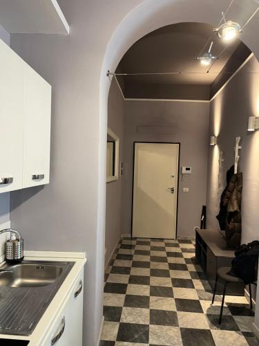 a kitchen with a checkered floor and a door at Cristina e Elena Suite in Pisa