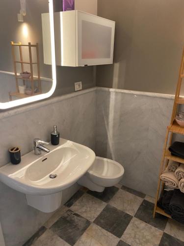 a bathroom with a white sink and a toilet at Cristina e Elena Suite in Pisa