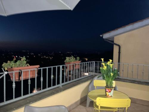 a balcony with two chairs and a table with flowers at A casa di Miele in Campagnano di Roma