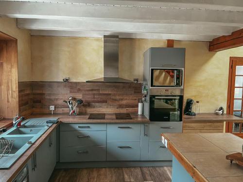 La cuisine est équipée de placards bleus et d'un four avec plaques de cuisson. dans l'établissement logement proche de nimes, à Nîmes