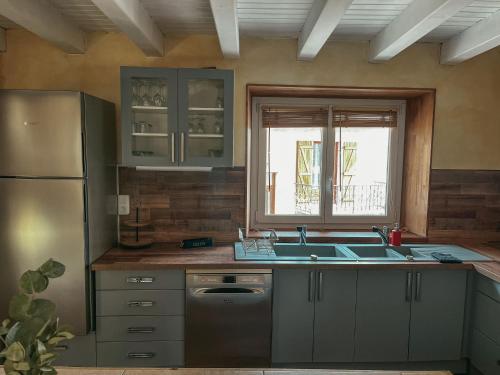 une cuisine avec un évier et un réfrigérateur dans l'établissement logement proche de nimes, à Nîmes