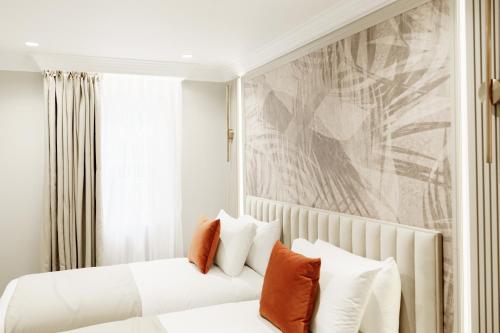 a bedroom with two beds and a painting on the wall at Holland Park Residence in London