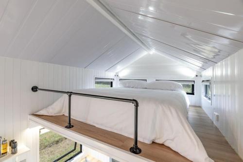ein Schlafzimmer mit einem Bett in einem weißen Zimmer in der Unterkunft Vineyard Retreat in Toolleen