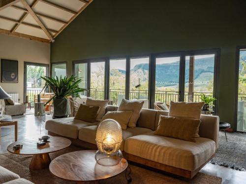 a living room with a couch and tables and windows at Hôtel le Tuit-Tuit in La Plaine des Palmistes