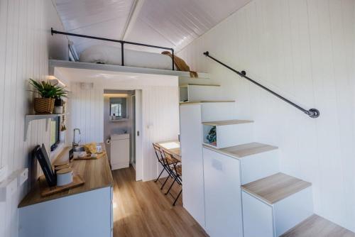 ein kleines Apartment mit einer Treppe und einem Esszimmer in der Unterkunft Blackiron Tiny House 