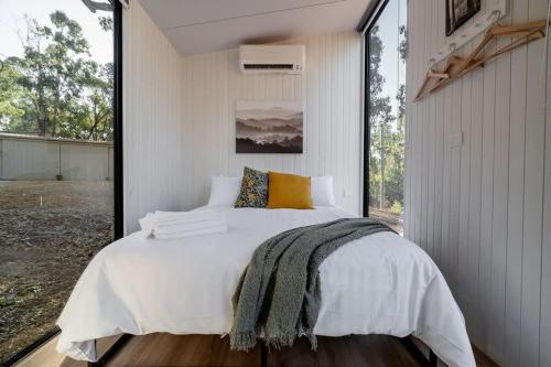 Schlafzimmer mit einem großen weißen Bett und einem Fenster in der Unterkunft Summer Lea in Howes Creek