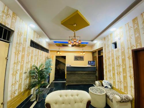 a living room with yellow walls and a couch and chairs at Karachi Inn in Karachi