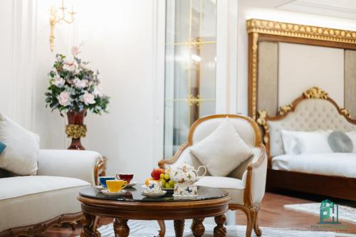 a living room with a coffee table and a bed at Luxe Paradise Suite Hotel Trich Sai in Hanoi