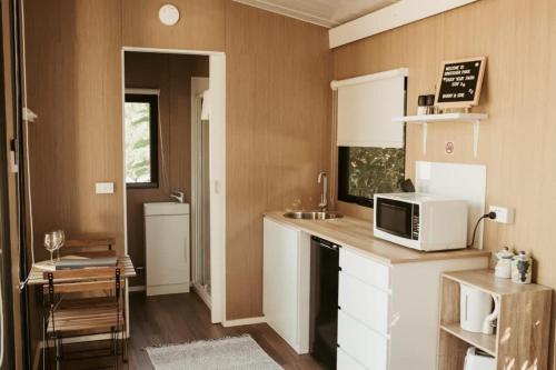 a kitchen with a microwave and a counter top at The Stables in Palmwoods