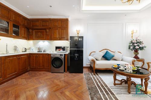 a kitchen and living room with a black refrigerator at Luxe Paradise Suite Hotel Trich Sai in Hanoi