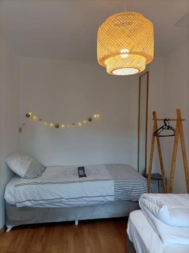 - une chambre avec un lit et un éclairage dans l'établissement Maison spacieuse avec cour arrière, au Tréport