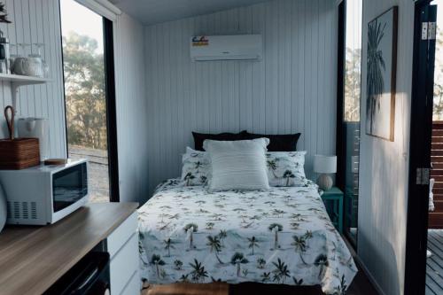 um quarto com uma cama e uma televisão em Tiny Tamborine 1 em Wongawallan