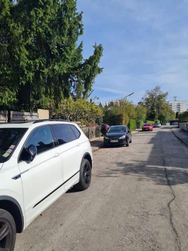 een witte auto geparkeerd aan de kant van een weg bij Garden Oasis Retreat: Apartment with Terrace in München