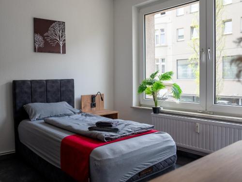 a bedroom with a bed and a large window at SR24 - Wohnung in Duisburg 4 in Duisburg