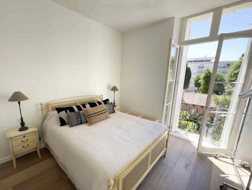 une chambre avec un lit et une grande fenêtre dans l'établissement Beautifully renovated 3 bedroom apartment in the heart of Cannes, à Cannes