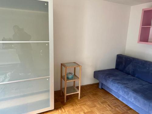 Habitación con sofá azul y estante en Garden Oasis Retreat: Apartment with Terrace, en Múnich