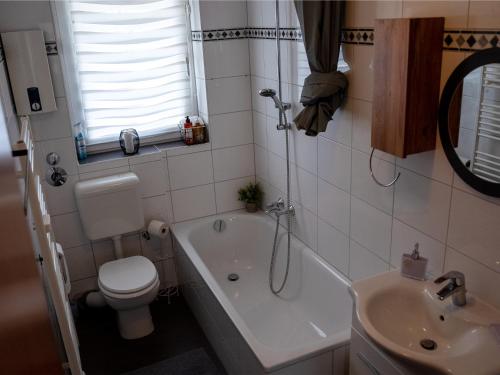 a bathroom with a tub and a toilet and a sink at SR24 - Wohnung in Duisburg 4 in Duisburg