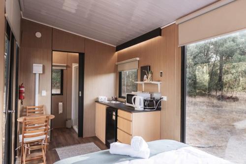 a room with a bed and a kitchen with a microwave at Wally's Retreat 1 in Balingup