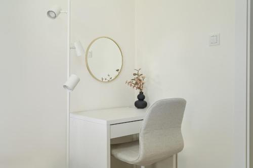 a white desk with a chair and a mirror at Family Apartment in Poznań with 2 Parking Spaces, 3 Bedrooms and Balcony by Renters in Poznań