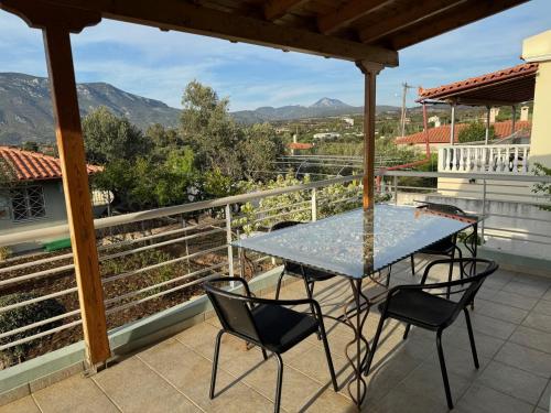 einen Tisch und Stühle auf einem Balkon mit Aussicht in der Unterkunft Villa Korina in Posidhonía